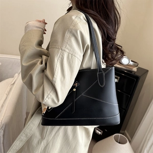 Fashionable black tote bag for women featuring white contrast stitching and a large capacity