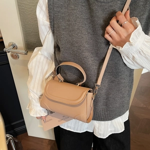 Chic khaki small square crossbody bag with handle and metal buckle shown in lifestyle setting
