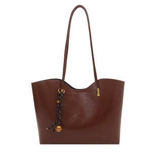 Minimalist deep brown large tote bag with wavy top edge and woven charm detail