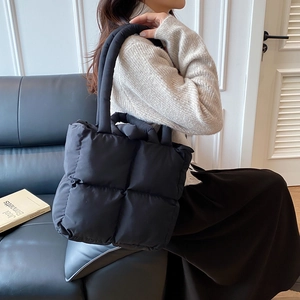 Minimalist black quilted tote bag for women with padded handles and puffer design