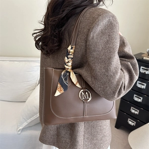 Large dark brown leather tote bag with M logo buckle and decorative silk scarf
