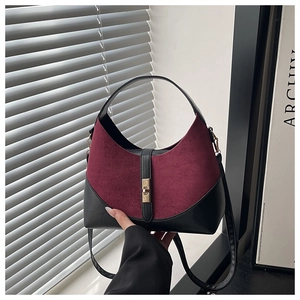 Dettaglio della borsa patchwork in camoscio bordeaux e pelle nera con fibbia dorata