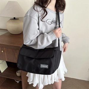 Minimalist large black nylon tote bag with fashion label and adjustable shoulder strap