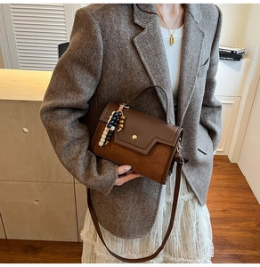 Sac à main rétro en cuir marron avec breloques en perles sur une tenue élégante
