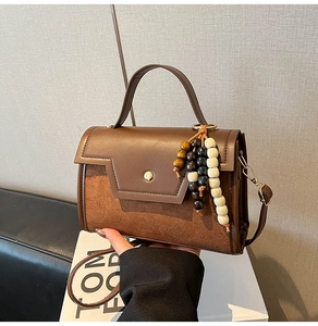 Vue détaillée du sac en similicuir marron avec patchwork en daim et perles en bois