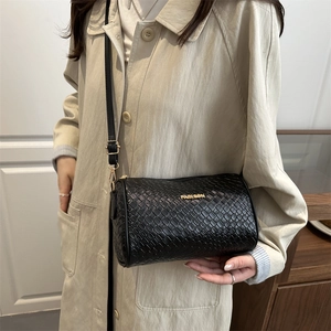 Chic sac bandoulière cylindrique noir en cuir tressé avec détails dorés élégants