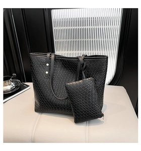 Detail of black woven leather tote bag set featuring a matching zippered interior pouch