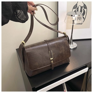 Détail du sac bandoulière marron vintage avec boucle dorée et bandoulière réglable