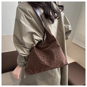 Detail of vintage leopard print suede tote bag with brown leather strap shown on a shoulder