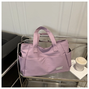 Dettaglio della borsa tote in nylon lilla con etichetta Fashion su scaffale d'argento