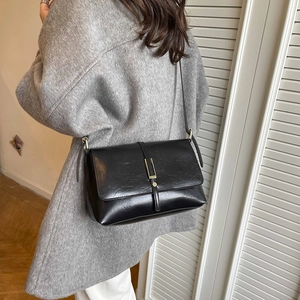 Sac bandoulière noir chic pour femme avec boucle dorée et texture vintage élégante