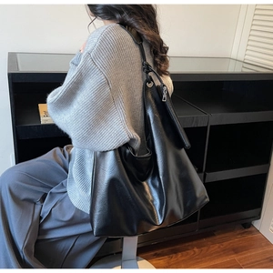 Detail einer großen schwarzen Leder-Tote-Bag mit Metallreißverschluss und glatter Textur