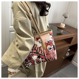 Chic graffiti print tote bag worn by a model in a cozy indoor setting with warm lighting