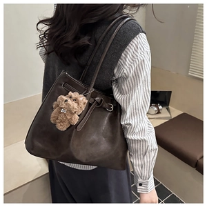 Détail du grand sac cabas marron foncé avec texture rétro et breloque chien en peluche