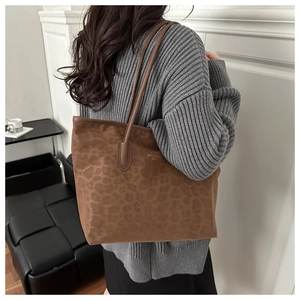Detail of faux suede leopard print tote bag with gold logo and long shoulder straps
