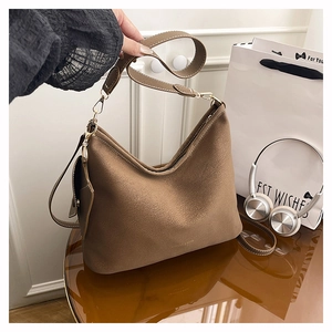 Close-up of brown suede hobo bag with adjustable strap and small side pouch detail