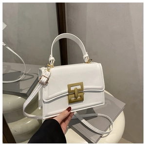 Detailed view of white leather crossbody bag with distinctive gold-tone metallic buckle