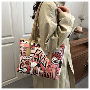 Close-up of cute tote bag with cartoon graffiti print on khaki trench coat look