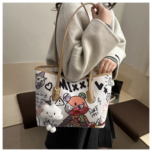 Detail of canvas tote bag with cartoon bear graffiti and white cloud plush charm