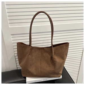 Close-up of brown suede tote bag with textured surface and fine stitching detail