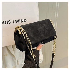 Detail van de zwarte gewatteerde suède schoudertas met luxe gouden metalen ketting