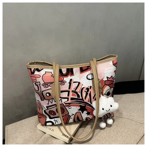 Detail of graffiti tote bag with pink retro illustrations and plush cloud charm accessory