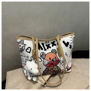 Detail of white graffiti canvas tote bag with brown leather handles and cloud charm