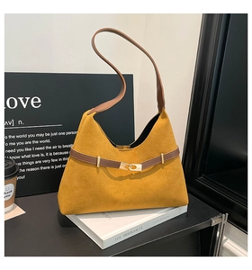 Detail of yellow suede tote bag with brown leather strap and golden matte metal buckle