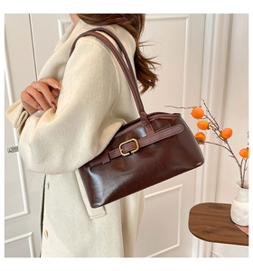 Détail du sac sous le bras marron foncé rétro avec boucle dorée sur cuir PU brillant