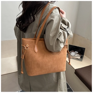 Detail of caramel suede tote bag with drawstring side and long slim shoulder straps