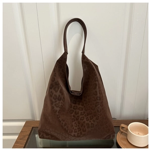 Brown leopard print large tote bag displayed on a stylish coffee table in a warm room