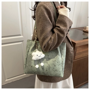 Detail of light green tote bag with star patterns and cloud plush charm accessory