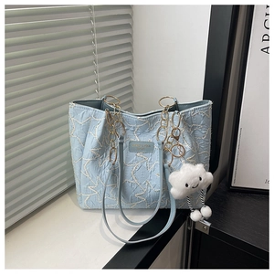 Detail of light blue tote bag featuring star embossed texture and a cute cloud charm