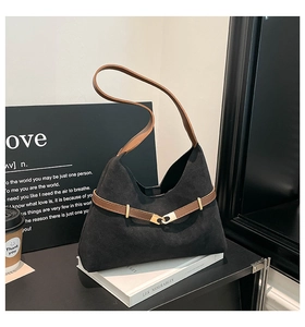 Detail of black suede tote bag featuring brown leather straps and gold metal buckle