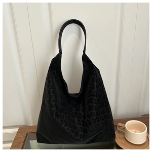 Detail of black leopard print texture and shoulder strap on a large tote bag
