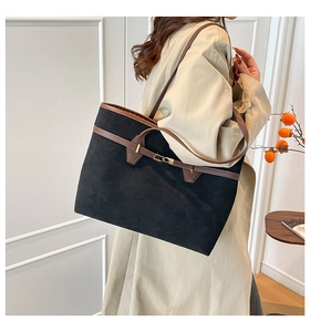 Detail of vintage matte tote bag showing brown leather trim and golden buckle hardware