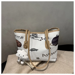 Detail of white canvas tote bag with space pattern and plush cloud charm accessory