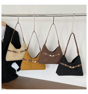 Close-up of four suede tote bags in beige, yellow, brown, and black hanging on display