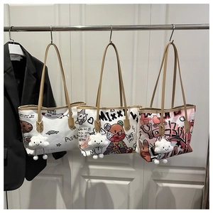 Detail view of graffiti canvas tote bags with leather straps and cloud charms