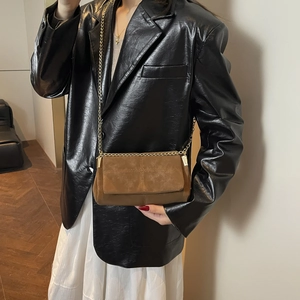 Bruine suède crossbody tas met gouden ketting en vintage stiksel op het model