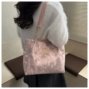 Pink tote bag with star and moon print featuring chain shoulder strap in detail view