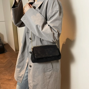 Minimalistische zwarte crossbody tas met gouden ketting voor wintermode