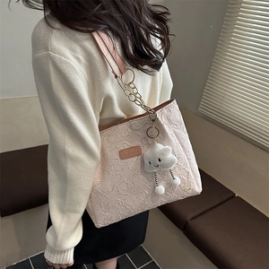 Light pink tote bag with 3D floral texture and gold chain shown on a model