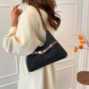 Retro black suede hobo shoulder bag with brown straps and silver buckle detail on a model