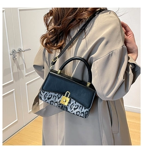 Detail view of a vintage leopard print shoulder bag worn with a khaki trench coat