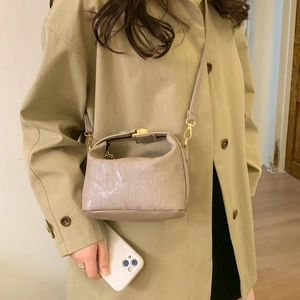 Minimalist oatmeal textured square handbag with vertical pleats and golden metal buckle