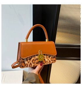 Detail of orange-brown leather and leopard print flap with golden padlock closure