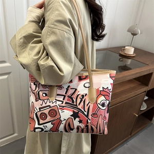 Graffiti canvas tote bag with brown faux leather straps shown in a cozy interior setting
