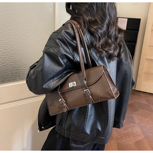 Vue détaillée latérale d'un sac sous le bras en cuir marron rétro avec boucles et serrure