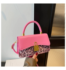 Detail view of pink leather and leopard print handbag with a golden metal buckle lock